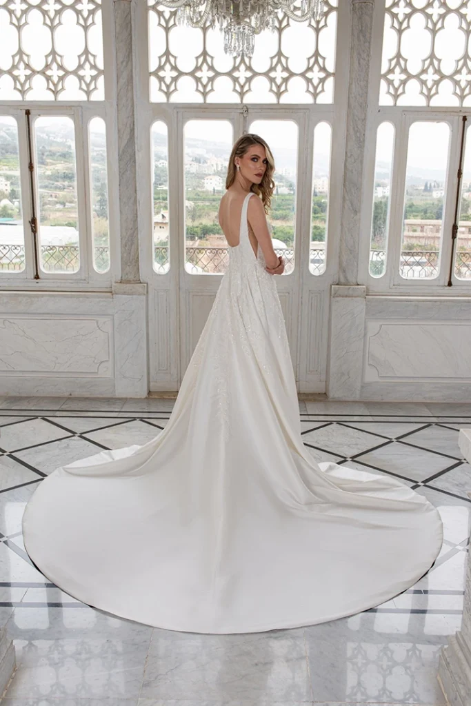 Back of A-line wedding dress with square neckline, side cutouts, and chapel train