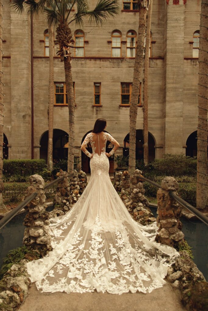 wedding dress with low back and lace train at a beautiful venue